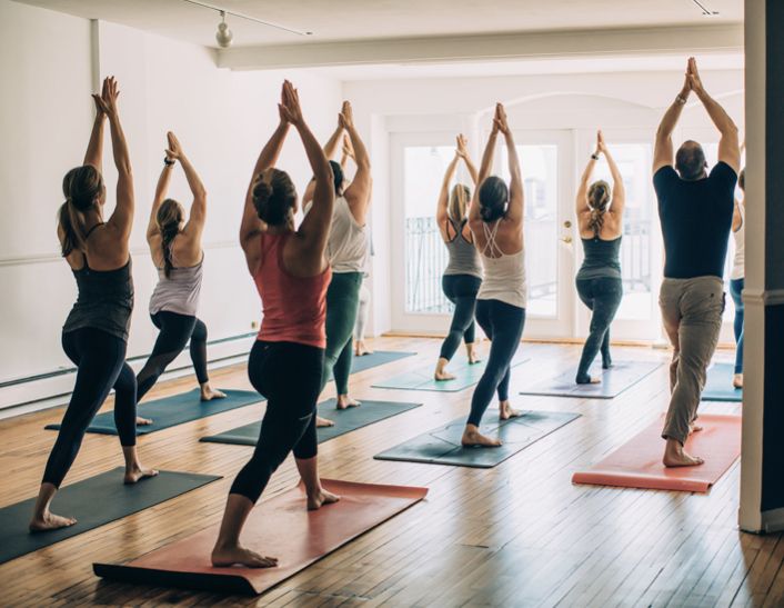Participants practicing bodyweight movements during an indoor floor-based fitness workshop