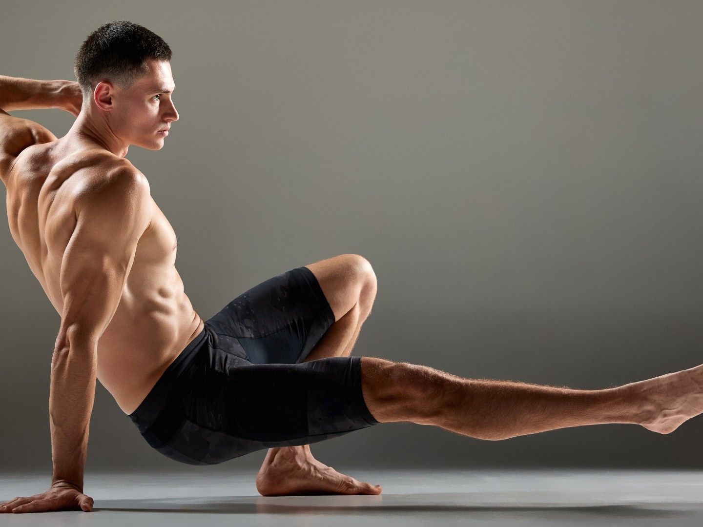 Instructor demonstrating a controlled bodyweight flow sequence on a mat
