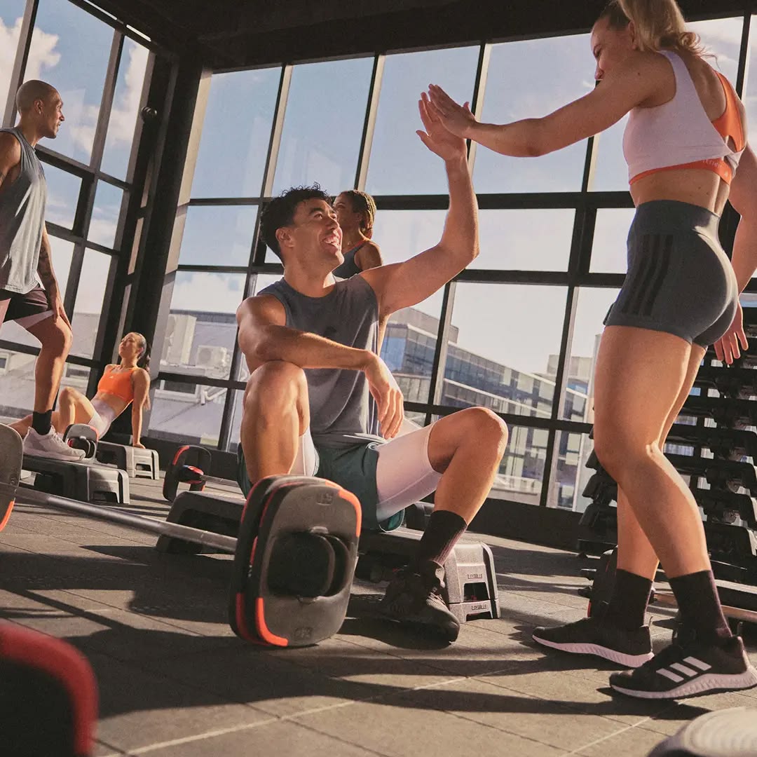 Fitness instructor coaching a small group through a bodyweight exercise sequence